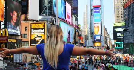 au pair mit ausgestreckten armen am times square