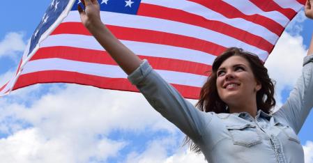 Junge Frau hält USA Flagge über ihren Kopf