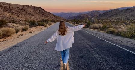 Der Vermittlungsprozess Au pair läuft in der Wüste mit ausgebreiteten Armen den Highway runter