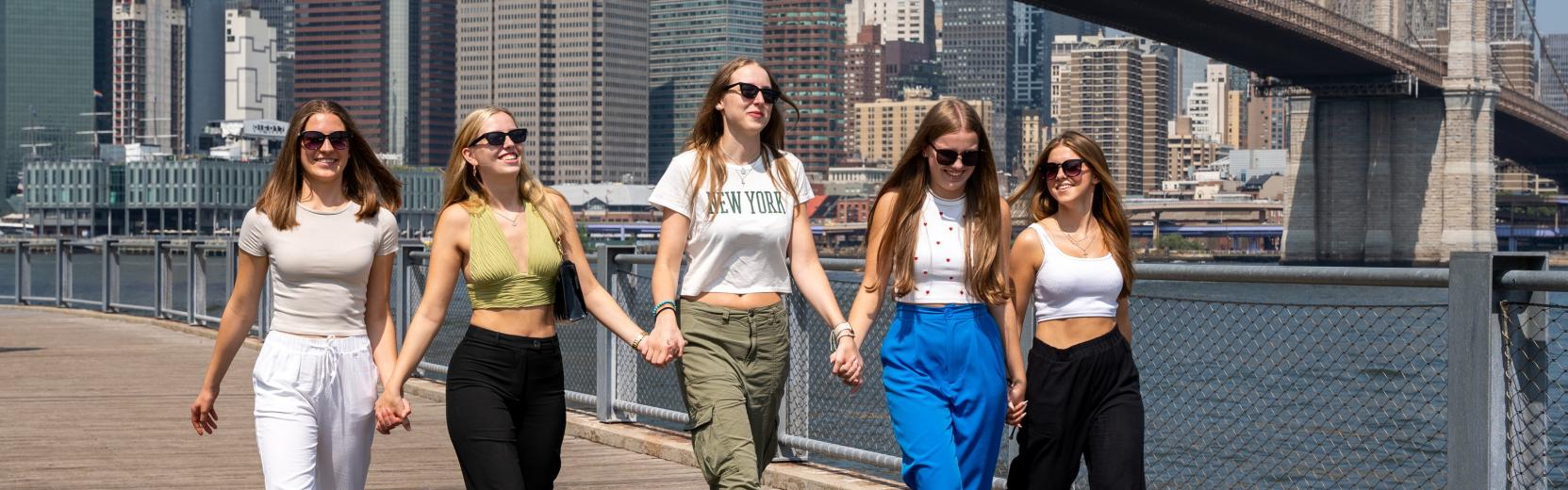 Entdecke als Au pair die USA fünf au pairs laufen nebeneinander vor der Brooklyn Bridge
