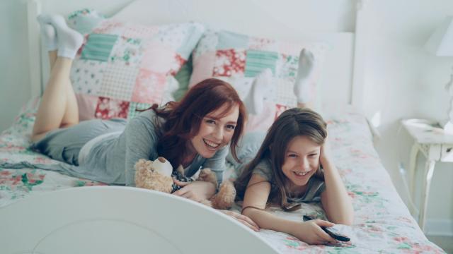 Au pair mit Gastkind auf dem Bett