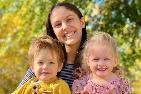 au pair mit zwei kleinen Kindern auf dem Schoss